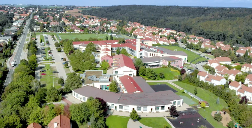 Aerial view of the International School of Prague campus and surrounding green landscape in Prague 6.