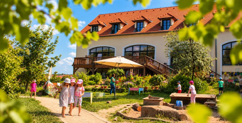 Children enjoying everyday outdoor life in the natural garden of MŠ Semínko at Toulcův dvůr in Prague.