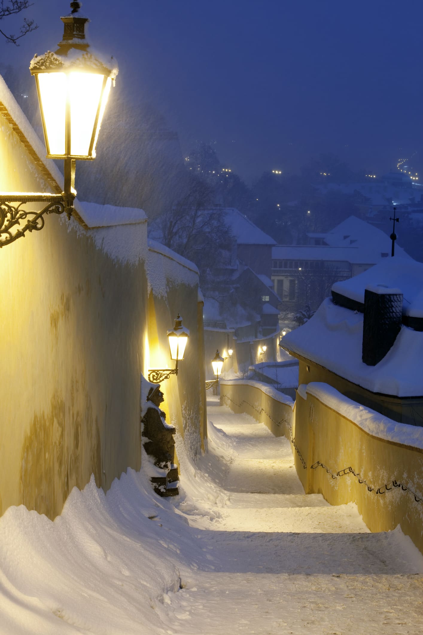 Snow-covered stairs leading from Prague Castle down towards Malostranská.