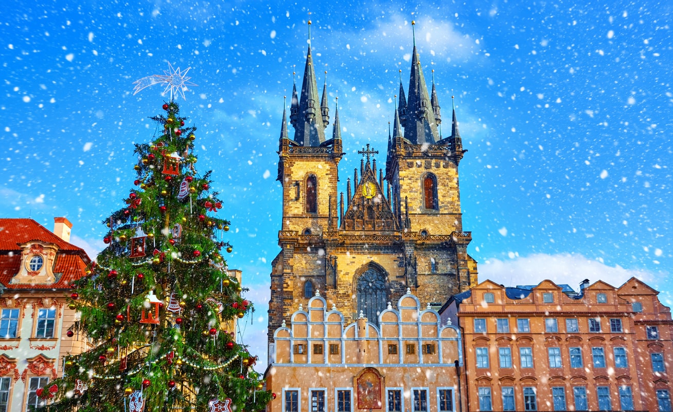 Snow falls over the famed Christmas Market Prague's Old Town Square, Czech Republic in front of Church of Our Lady Before Týn.