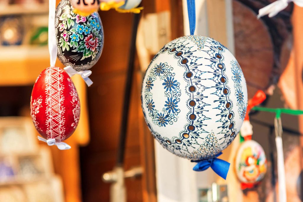 Wide selection of easter eggs, traditional souvenirs in the kiosk of street market during celebration of Easter in Central Europe. Compartments full of colourfull eggs. Focus on white egg.