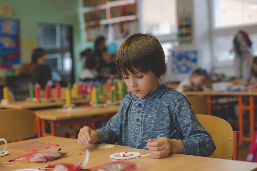 Elementary age child, creating art and craft product, dream catcher at school in art class, classroom, Christmas products