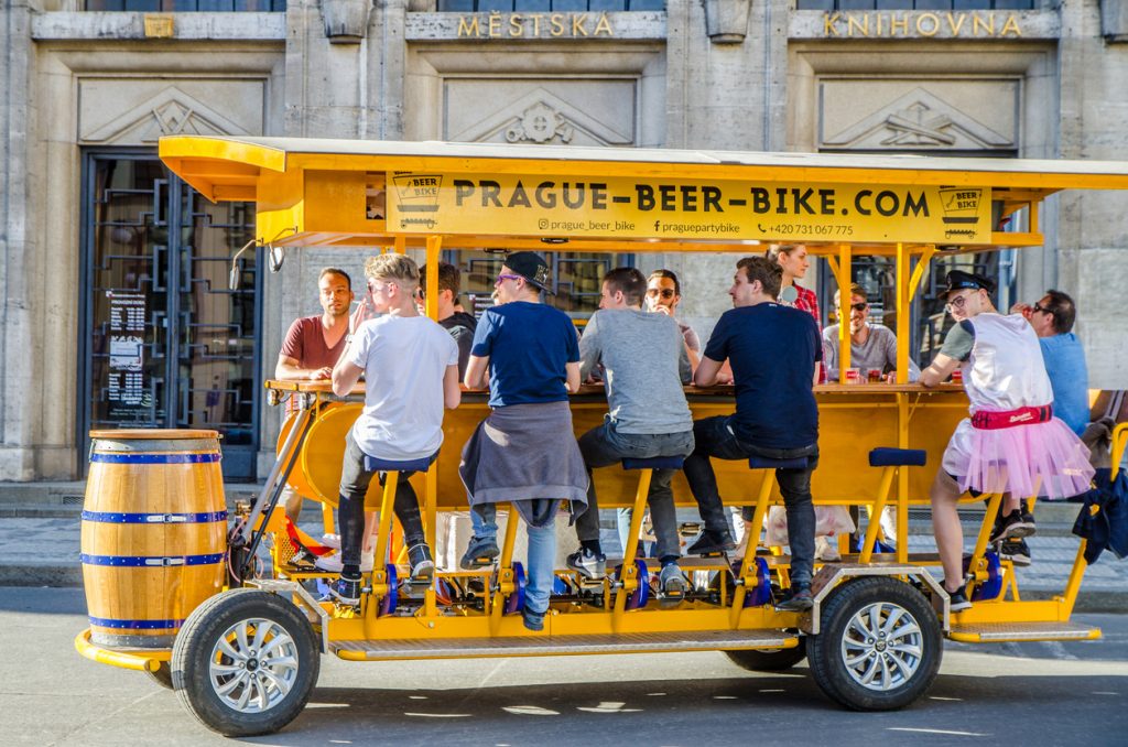 Tourists pedal a beer bike through the center of Prague